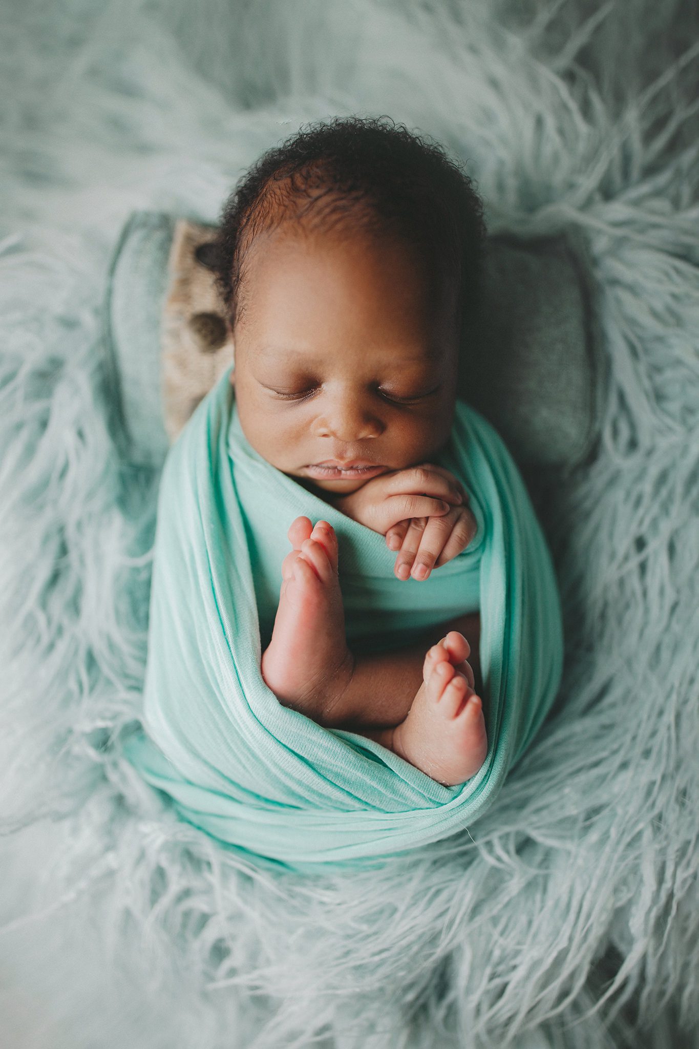 Kansas City Newborn Photographer baby wrapped in flokati