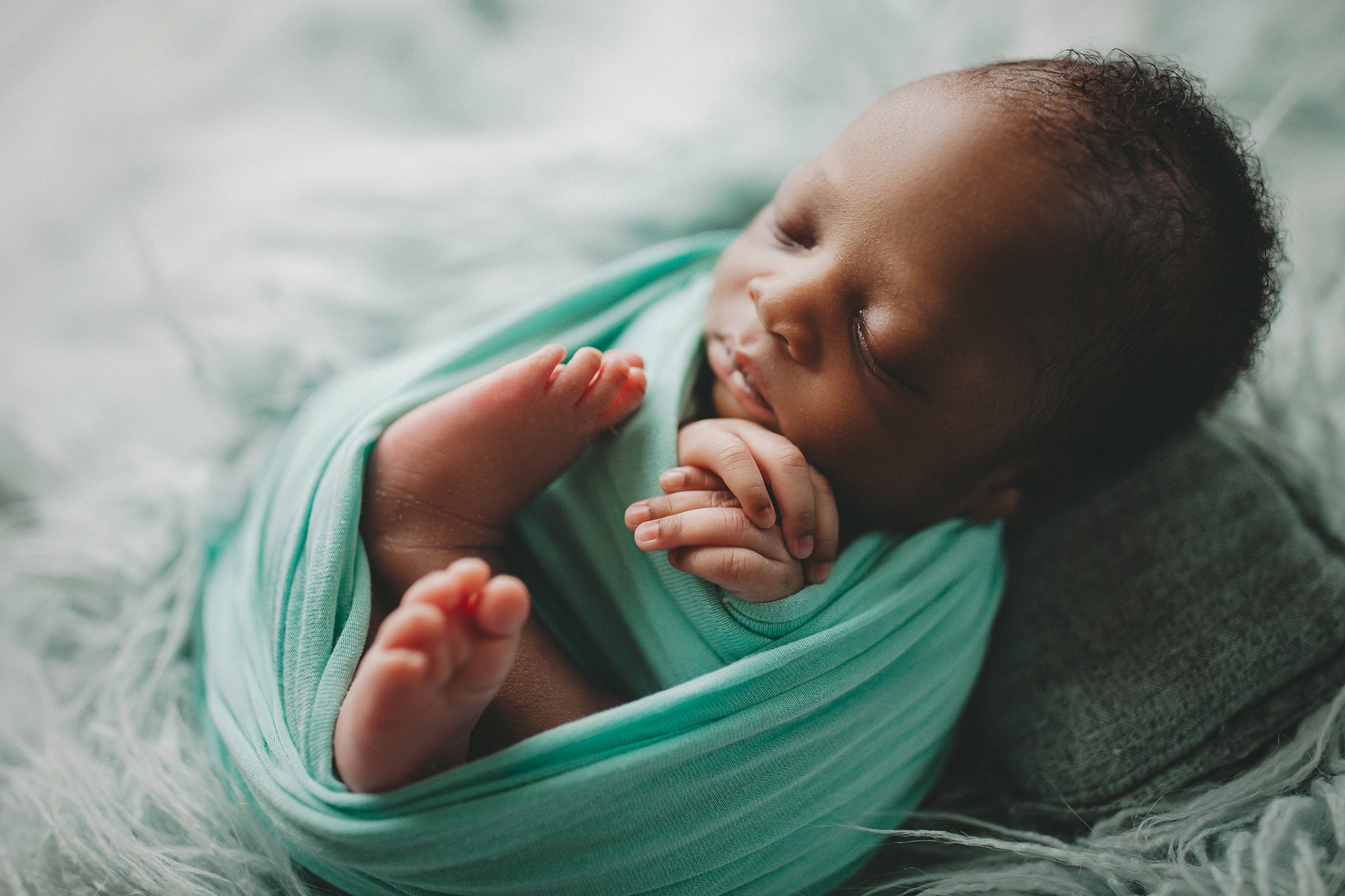 Kansas City Newborn Photographer wrapped on flokati